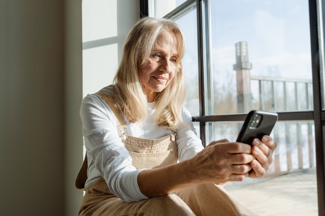 Rentnerin prüft Rentenbescheid auf Smartphone